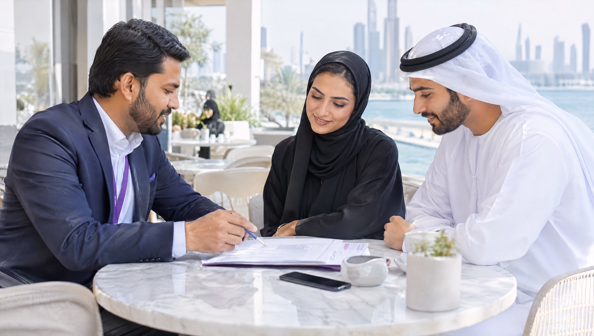 An adviser going through papers with a couple at a café table