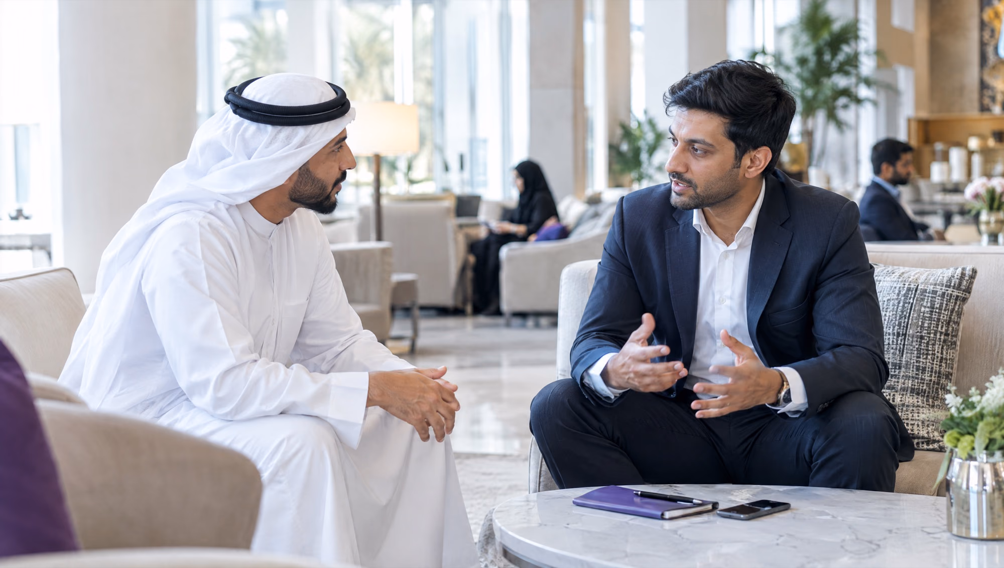 An independent consultant in conversation with a client in a hotel lobby lounge